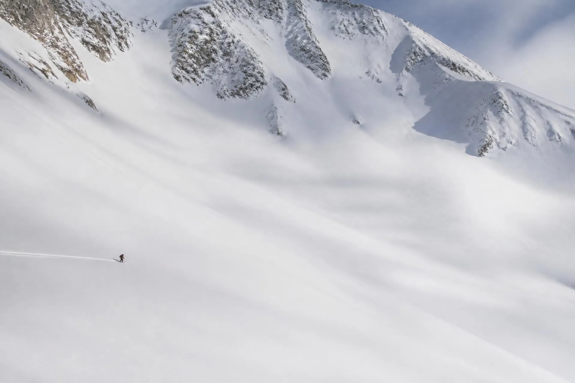 Un skieur seul dans un paysage de montagne immense